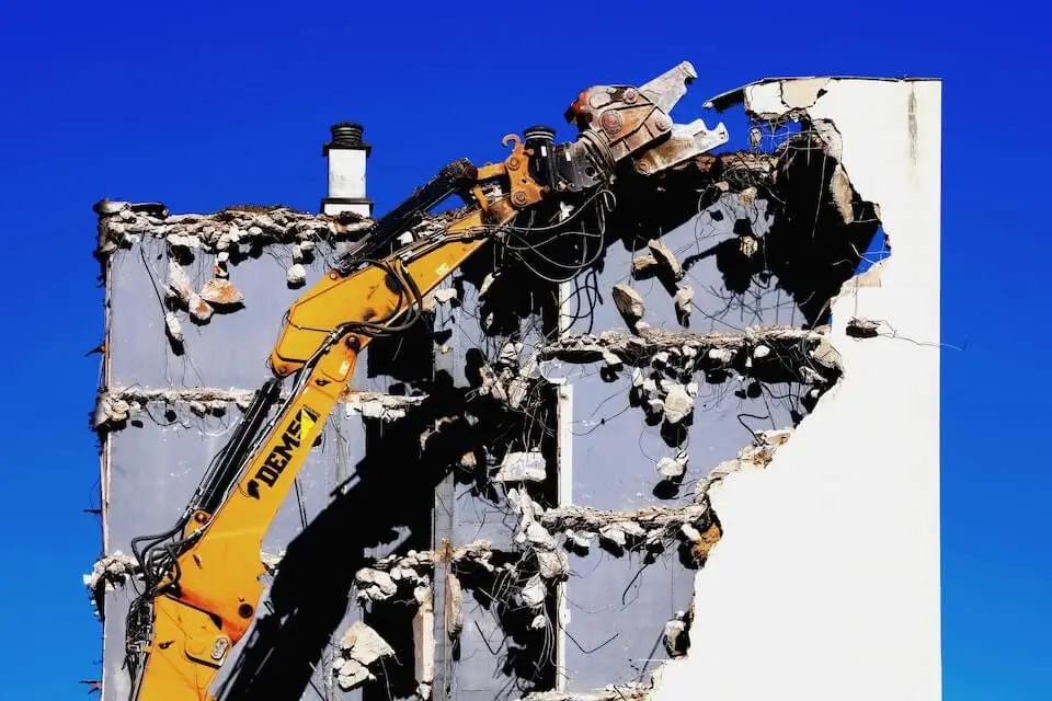 Weisses Haus wird gerade abgerissen. Knallblauer Himmel im Hintergrund.